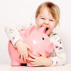 Lachendes Mädchen umarmt großes Sparschwein